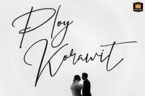 Couple’s portrait at Conrad Bangkok, standing beneath a sign with their names written in cursive above them.